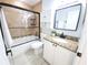 Bathroom featuring tiled shower-tub combo with black hardware, tiled flooring, granite counters, and white cabinets at 2935 Lichen Ln # D, Clearwater, FL 33760