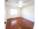 Vacant bedroom features hardwood floors, a ceiling fan and natural light at 2935 Lichen Ln # D, Clearwater, FL 33760