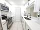 Well-lit kitchen featuring white cabinetry, stainless steel appliances, and tiled flooring at 2935 Lichen Ln # D, Clearwater, FL 33760