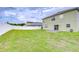 Large back yard with green grass, white fence, and a concrete patio at 3012 Magnolia Meadows Dr, Plant City, FL 33567