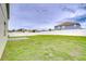 Large, fenced backyard with ample green space and a concrete patio area at 3012 Magnolia Meadows Dr, Plant City, FL 33567