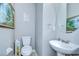 Powder room featuring pedestal sink and toilet with decorative wall art at 3012 Magnolia Meadows Dr, Plant City, FL 33567