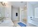 Bright bathroom featuring double sinks with large mirror, tiled floor, and a glass shower and tub at 3012 Magnolia Meadows Dr, Plant City, FL 33567