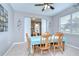 Bright dining room with a ceiling fan, table set for six, and a view of the outdoors at 3012 Magnolia Meadows Dr, Plant City, FL 33567