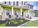 Charming front porch with stone columns, seating area, and well-maintained landscaping at 3012 Magnolia Meadows Dr, Plant City, FL 33567