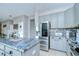 Stylish kitchen featuring gray cabinets, stainless steel appliances, beautiful counters, and an island at 3012 Magnolia Meadows Dr, Plant City, FL 33567