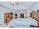 Spacious main bedroom with tray ceiling, ceiling fan, and large bed featuring access to sitting room with bookcases at 3012 Magnolia Meadows Dr, Plant City, FL 33567