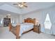 Spacious main bedroom featuring a large bed, vaulted ceilings, and views to a sitting area and bookcase at 3012 Magnolia Meadows Dr, Plant City, FL 33567