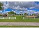 Community playground with green lawn and white fence at 3012 Magnolia Meadows Dr, Plant City, FL 33567