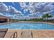View of the neighborhood pool with lounge chairs overlooking a pond at 3012 Magnolia Meadows Dr, Plant City, FL 33567