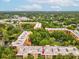 An aerial view shows the condo complex and surrounding lush greenery on a partly cloudy day at 3062 Eastland Blvd # 405, Clearwater, FL 33761