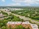 Aerial view of condo building with red arrow with surrounding trees and a long commercial road nearby at 3062 Eastland Blvd # 405, Clearwater, FL 33761