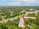 Aerial view of condo building with red arrow, highway, pond, and lots of surrounding trees at 3062 Eastland Blvd # 405, Clearwater, FL 33761