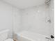 White tiled shower and tub combination featuring a modern shower head at 3062 Eastland Blvd # 405, Clearwater, FL 33761