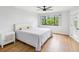 Bright bedroom with a large window, wood floors, and a side door for easy access at 3062 Eastland Blvd # 405, Clearwater, FL 33761