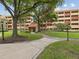 Exterior view of a multi-story building featuring well-maintained landscaping and a welcoming entrance at 3062 Eastland Blvd # 405, Clearwater, FL 33761