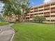 Beautiful multi-story condo building surrounded by lush landscaping, including palm trees and green lawns at 3062 Eastland Blvd # 405, Clearwater, FL 33761
