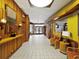 A well-lit interior hallway with tile flooring, wood paneling and comfortable seating areas at 3062 Eastland Blvd # 405, Clearwater, FL 33761