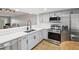 Modern kitchen with stainless steel appliances, gray cabinets, and a view to the living area at 3062 Eastland Blvd # 405, Clearwater, FL 33761