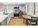 Stylish kitchen with stainless steel appliances, light gray cabinets, and a cozy dining area at 3062 Eastland Blvd # 405, Clearwater, FL 33761