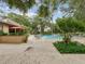 A beautiful in-ground pool surrounded by lush landscaping, comfortable lounge chairs, and mature trees at 3062 Eastland Blvd # 405, Clearwater, FL 33761