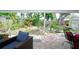 Covered back porch with chairs overlooks a large backyard with mature trees and landscaping at 3217 Saddlebrook Ave, Tampa, FL 33618