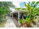 Wide view of a tropical backyard with a covered patio and lush landscaping at 3217 Saddlebrook Ave, Tampa, FL 33618