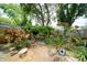 Beautiful backyard has mature landscaping and an arbor with seating beneath at 3217 Saddlebrook Ave, Tampa, FL 33618