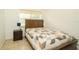 Well-lit bedroom with a patterned quilt, a dark wood bed frame and side table at 3217 Saddlebrook Ave, Tampa, FL 33618