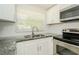 Modern kitchen with granite countertops, stainless steel appliances, and white cabinets at 3217 Saddlebrook Ave, Tampa, FL 33618