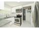 Well-lit kitchen with stainless steel appliances, white cabinets, and granite countertops at 3217 Saddlebrook Ave, Tampa, FL 33618