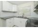 Bright kitchen featuring white cabinets, granite countertops, and stainless steel sink at 3217 Saddlebrook Ave, Tampa, FL 33618