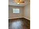 Clean bedroom featuring wood-look flooring, a ceiling fan, and natural light from a window at 3802 N Oak Dr # W22, Tampa, FL 33611
