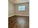 Bedroom with wood-look flooring and a bright window with blinds at 3802 N Oak Dr # W22, Tampa, FL 33611