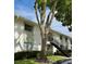 Building exterior featuring stairs leading to units, with a mature tree adding shade at 3802 N Oak Dr # W22, Tampa, FL 33611
