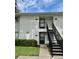 Condominium exterior showing the front entrances with a staircase and well-maintained landscaping at 3802 N Oak Dr # W22, Tampa, FL 33611