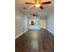 Open-concept living area showcasing dark wood floors, a ceiling fan, and partial view of the kitchen at 3802 N Oak Dr # W22, Tampa, FL 33611