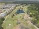 Aerial view of a pristine golf course with sand traps, a pond, and manicured greens at 3813 Salida Delsol Dr, Ruskin, FL 33573