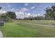 A lovely backyard with green grass, landscaping, and an expansive view of the golf course at 3813 Salida Delsol Dr, Ruskin, FL 33573