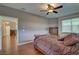 A primary bedroom suite featuring hardwood floors, ceiling fan, and an attached bathroom at 3813 Salida Delsol Dr, Ruskin, FL 33573