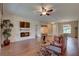 Inviting living room with hardwood floors, ceiling fan, stone accent wall with fireplace and a large window at 3813 Salida Delsol Dr, Ruskin, FL 33573