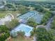 Aerial view of community pool and tennis courts surrounded by mature trees and green spaces at 3821 Turkey Oak Dr, Valrico, FL 33596