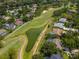 Scenic aerial view of a golf course winding through a residential community, featuring lush greens, ponds, and well-kept homes at 3821 Turkey Oak Dr, Valrico, FL 33596