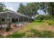 Large backyard with a screened pool and spa, surrounded by lush landscaping and mature trees at 3821 Turkey Oak Dr, Valrico, FL 33596