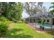 Spacious backyard with a screened pool, lush green lawn and mature landscaping at 3821 Turkey Oak Dr, Valrico, FL 33596