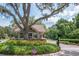 Community entrance featuring a guard house, lush landscaping, and patriotic American flags at 3821 Turkey Oak Dr, Valrico, FL 33596