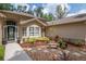 Inviting front entry with decorative planters, garden beds, and a stone bench at 3821 Turkey Oak Dr, Valrico, FL 33596