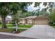Beautifully landscaped front yard with mature trees, lush lawn, and charming home exterior at 3821 Turkey Oak Dr, Valrico, FL 33596