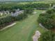 Picturesque aerial view of a lush golf course, complete with tree-lined fairways, serene ponds, and manicured greens at 3821 Turkey Oak Dr, Valrico, FL 33596