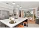 Open kitchen area features stainless appliances, black island with seating, and adjacent dining area with backyard view at 3821 Turkey Oak Dr, Valrico, FL 33596